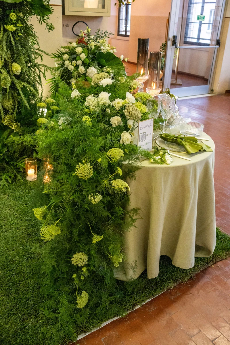 Allestimento floreale naturale con foglie e verdi intensi  Installazione floreale verde per matrimonio scenografico