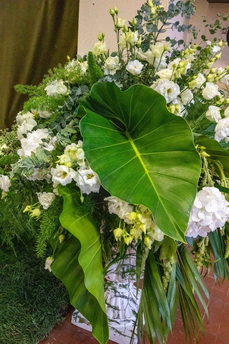 Allestimento floreale naturale con foglie e verdi intensi  Installazione floreale verde per matrimonio scenografico