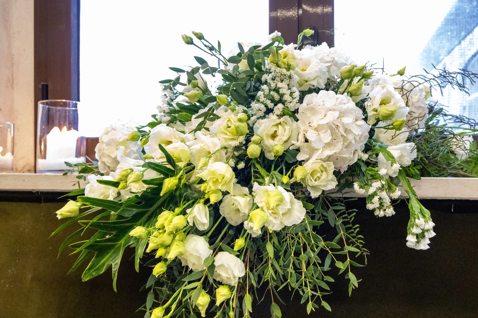 Allestimento floreale naturale con foglie e verdi intensi  Installazione floreale verde per matrimonio scenografico